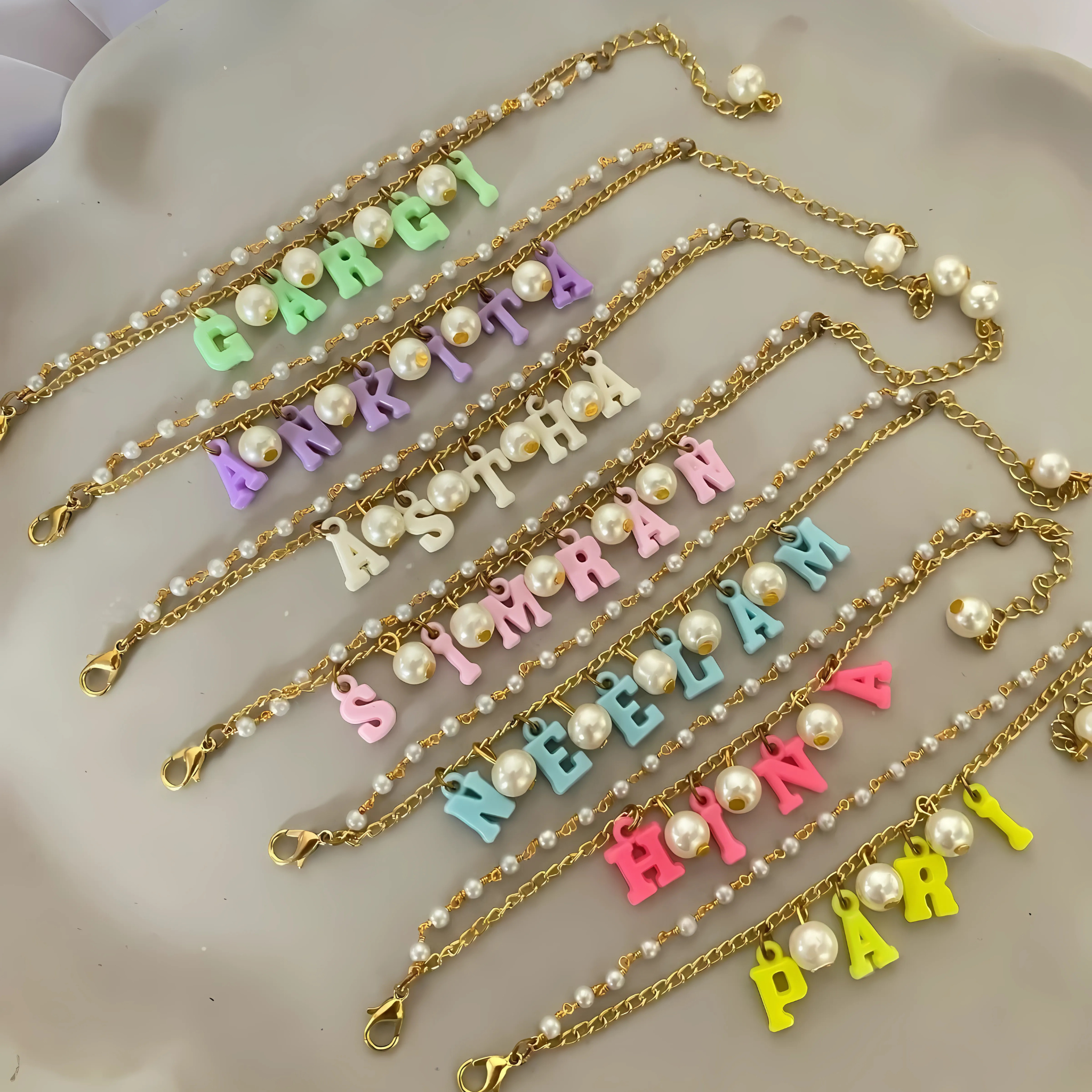 Personalized gold chain bracelet for sister with hanging name and pearls – Rakhi gift for modern girls.