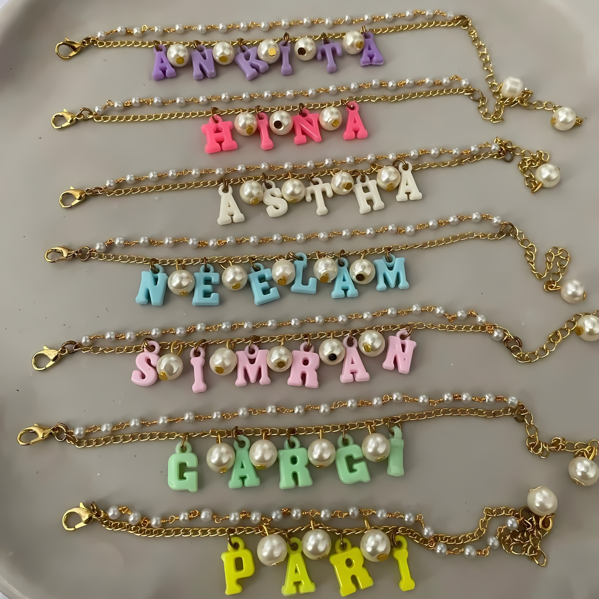 Personalized gold chain bracelet for sister with hanging name and pearls – Rakhi gift for modern girls.