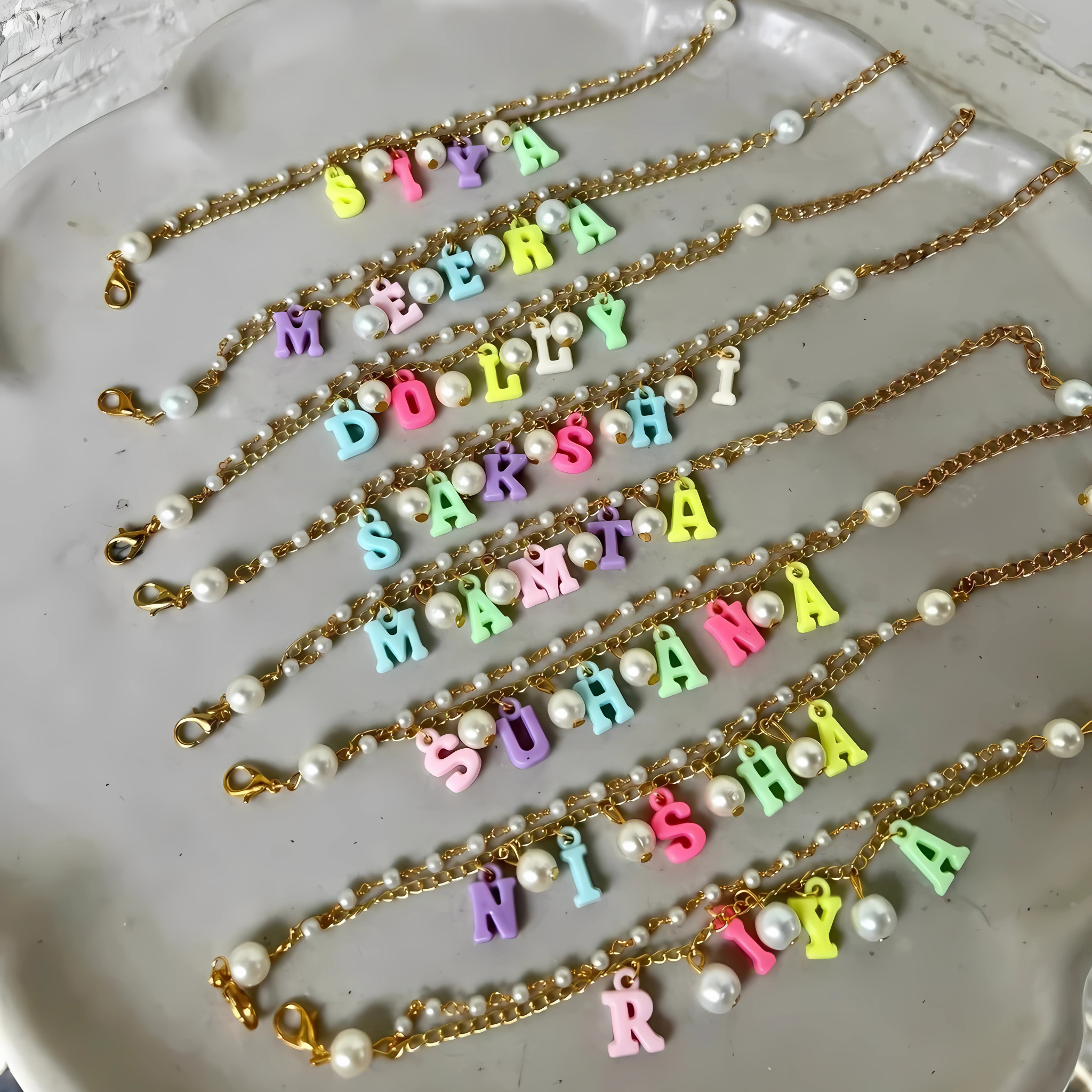 Personalized gold chain bracelet for sister with hanging name and pearls – Rakhi gift for modern girls.