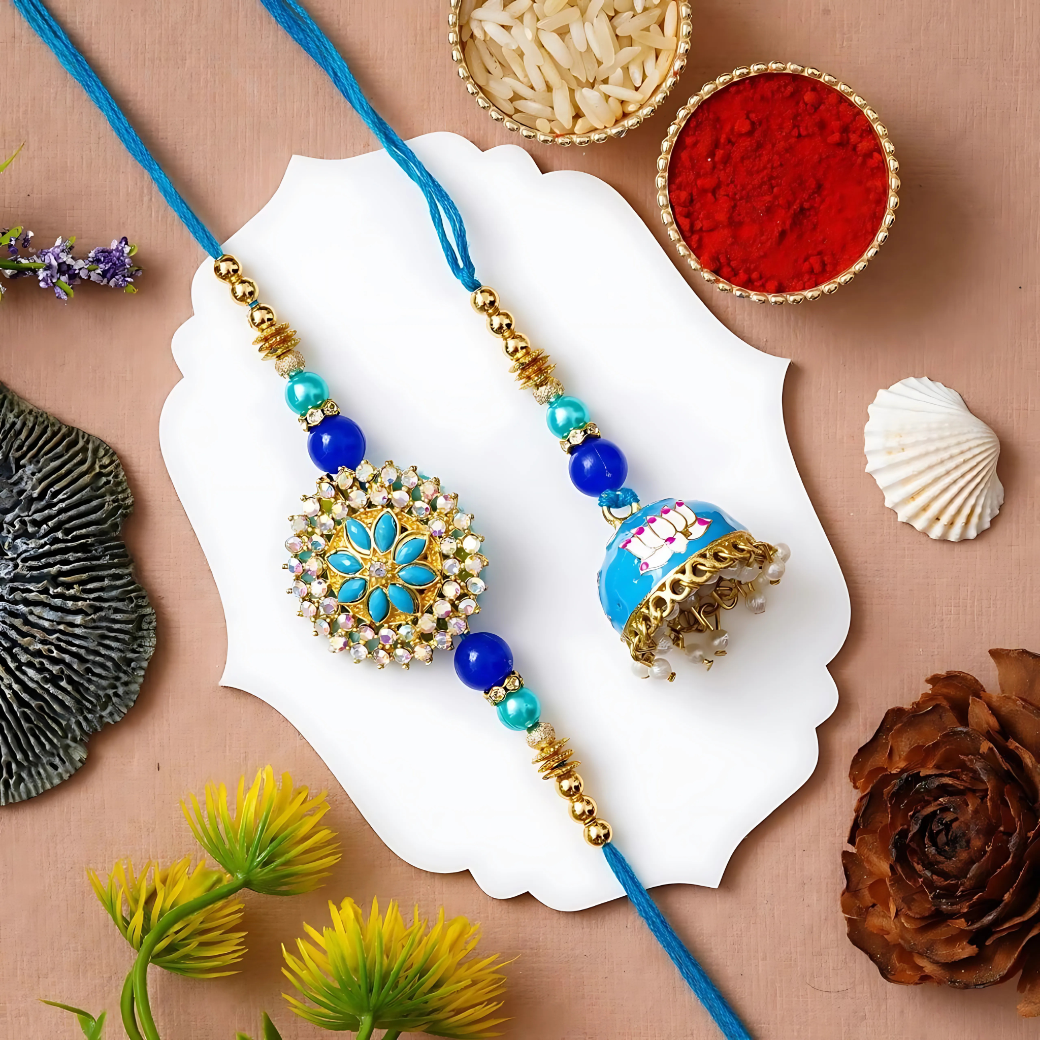 Blue and gold floral stone Rakhi set with crystal center and matching dome-shaped Lumba – festive Rakhi combo