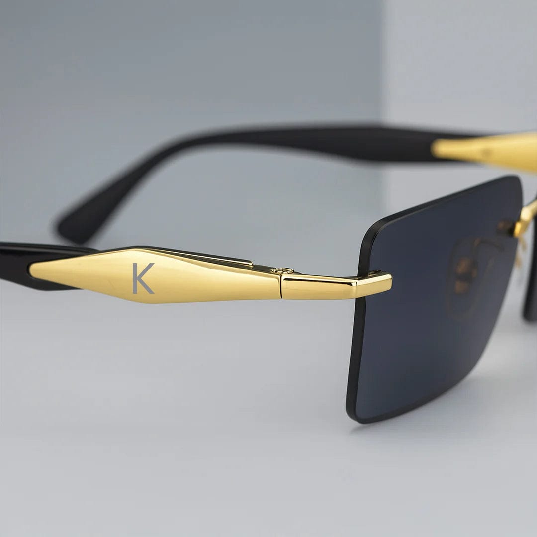 Close-up of frame-free sunglasses showing gold temple and deep black lens – premium gifting option for men