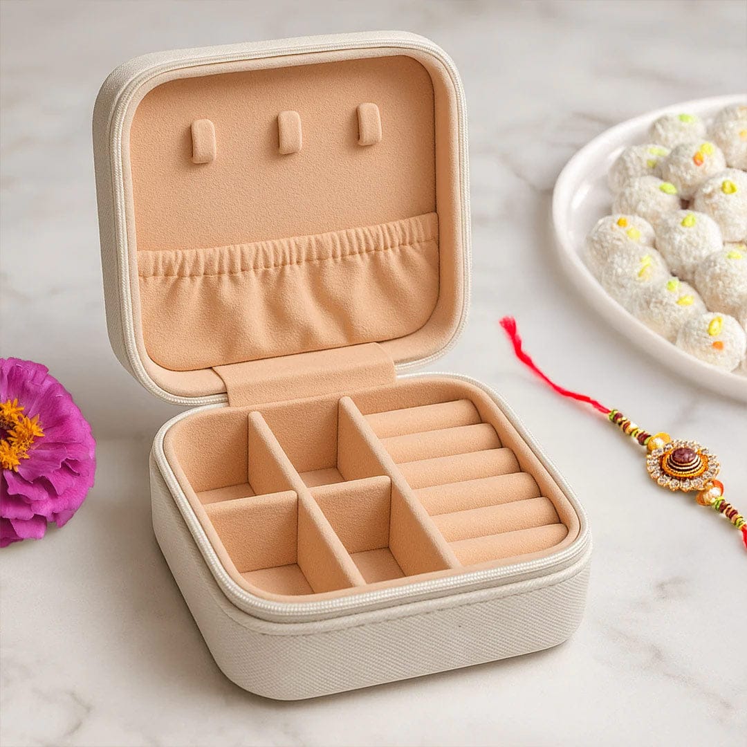 Open beige jewellery travel case with ring holders and compartments, styled with rakhi and sweets for Rakshabandhan
